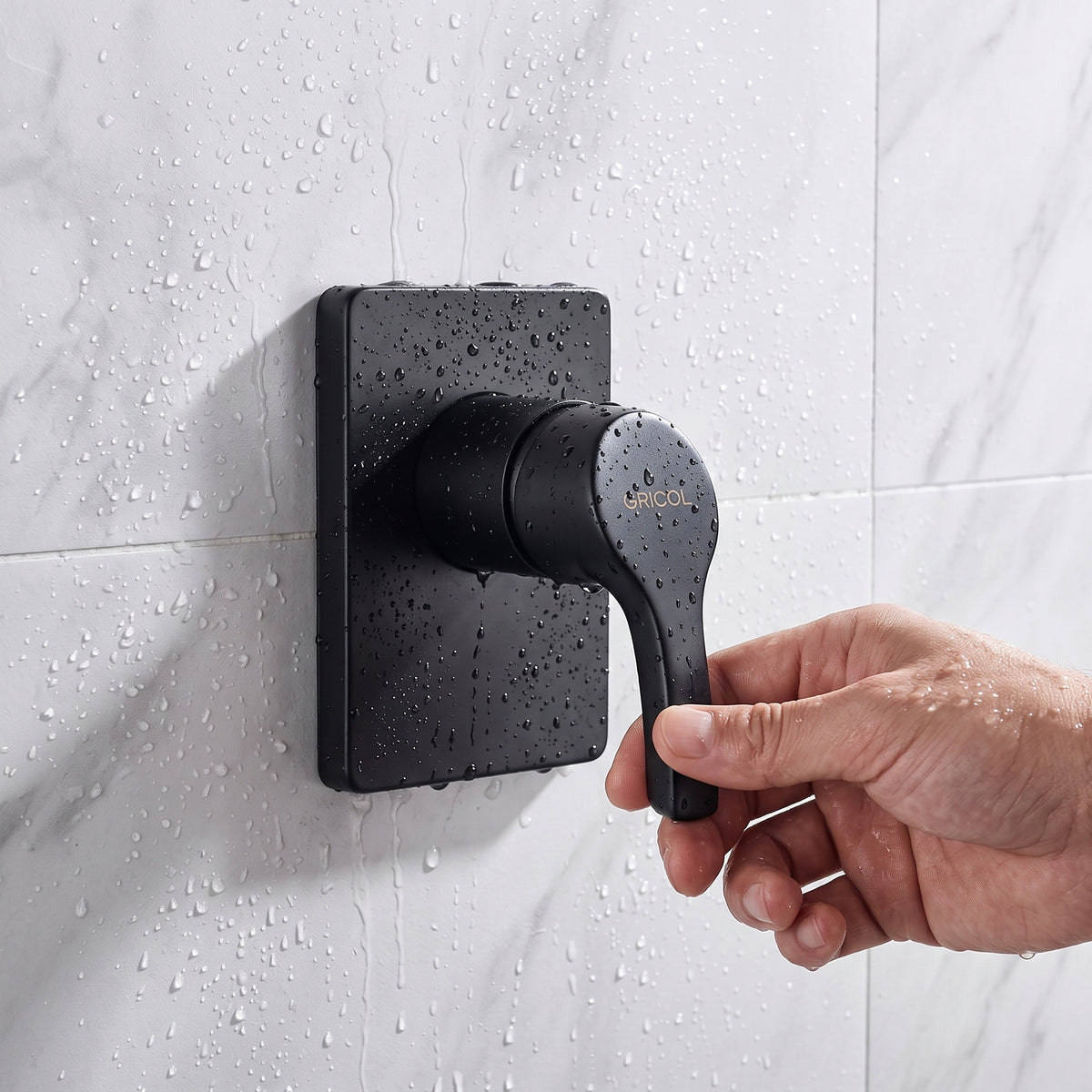 Ducha monomando Dante con escudo cuadrado en acabado negro mate, instalado en ambiente de baño conazulejo blanco