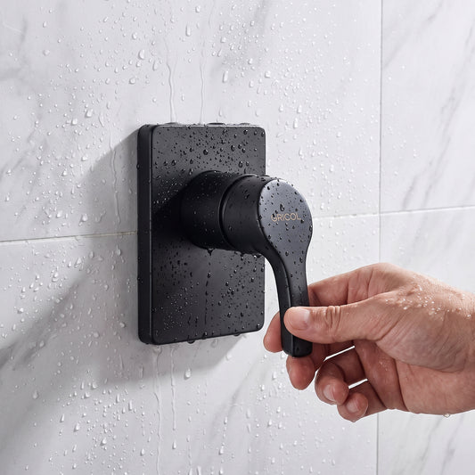 Ducha monomando Dante con escudo cuadrado en acabado negro mate, instalado en ambiente de baño conazulejo blanco