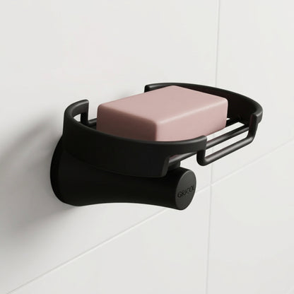 Jabonera rejilla Contempra en acabado negro mate, instalada en un ambiente de baño moderno con un jabón.
