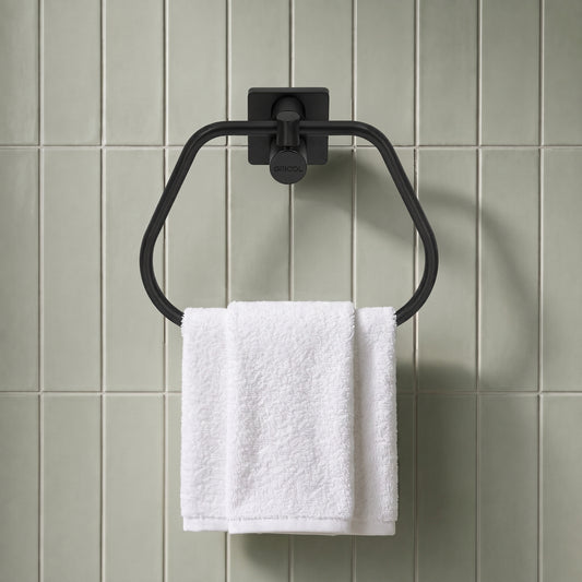 Toallero de aro génesis negro mate instalado en un ambiente de baño moderno con una toalla blanca.